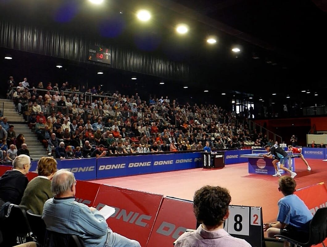Bénévoles et jeune marqueur au bord de l'aire de jeu du Kindarena