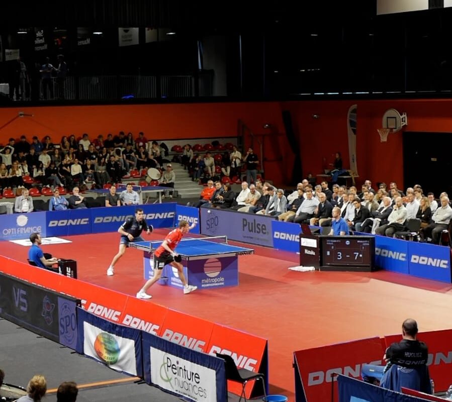 Vue large de l'aire de jeu du Kindarena avec les panneaux des partenaires du SPO Rouen